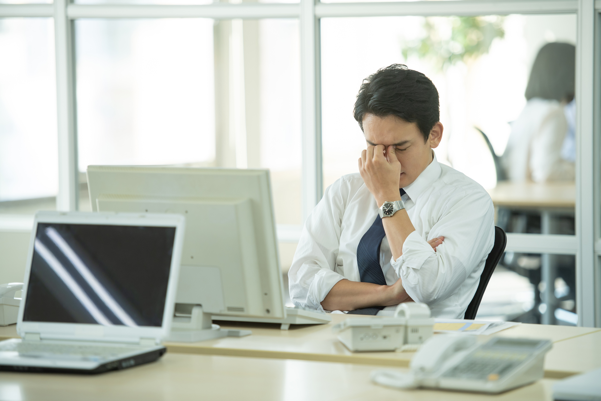 目頭を抑える男性